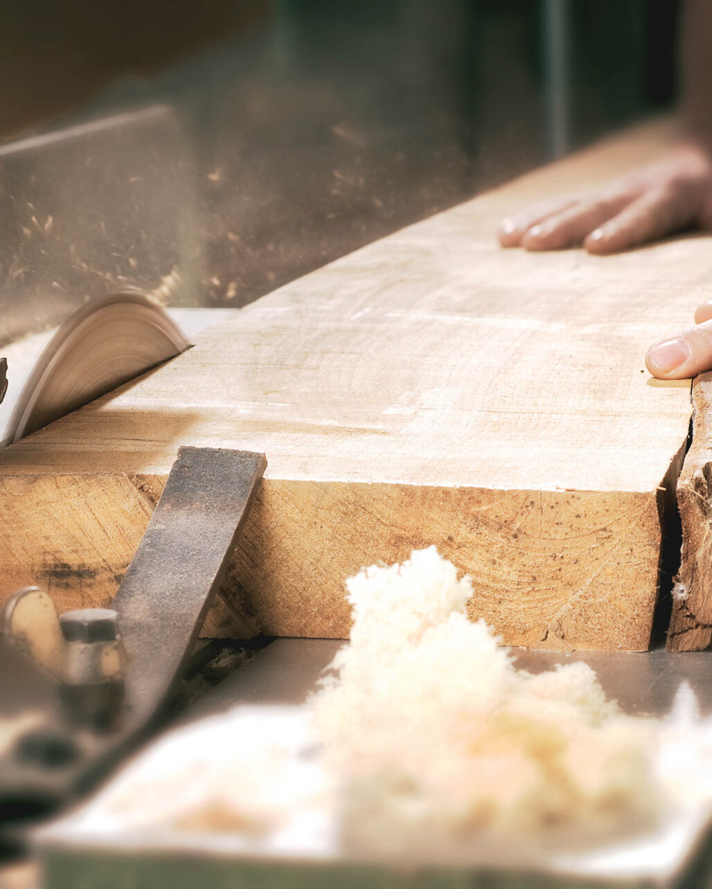 Das Holz wird roh auf einer Kreissäge geschnitten.